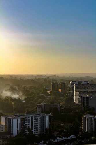 View over Nairobi with sunbeams cutting across a blue sky.
