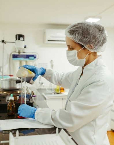 Woman in a lab pouring liquid into a test tube