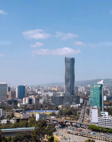 A view of Addis Ababa featuring a large highway and a prominent tall building in the city skyline.