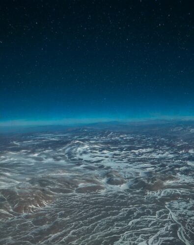 Aerial view of mountain during night time. Stars are visible in the background.