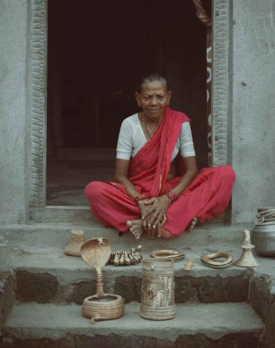 A woman sitting with crafts in Adilabad, Telangana, India. Photo by Divyanshi Verma.